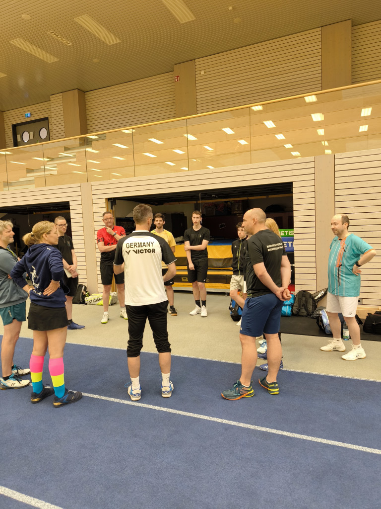 Badminton Training in Sporthalle mit Trainer und Spielern, Rückansicht, Germany Victor Trikot