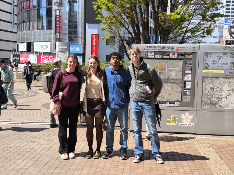 Gruppe junger Menschen vor dem Omiya Station West Gate Area Map in Japan bei sonnigem Wetter