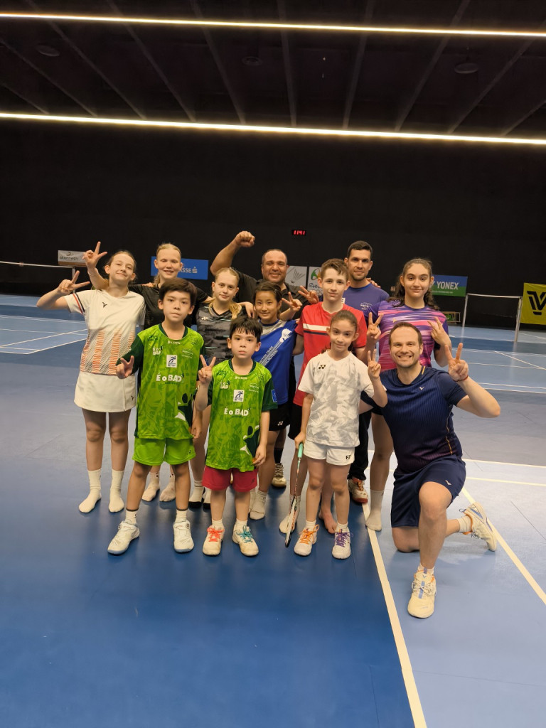 Gruppe von Kindern und Jugendlichen beim Badminton-Training in einer Sporthalle
