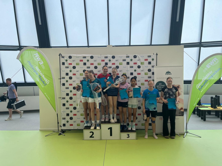 Siegerinnen bei Badminton-Turnier mit Urkunden und Preisen auf dem Podest Siegerinnen bei einem Badminton-Turnier auf dem Podest mit Urkunden und Preisen