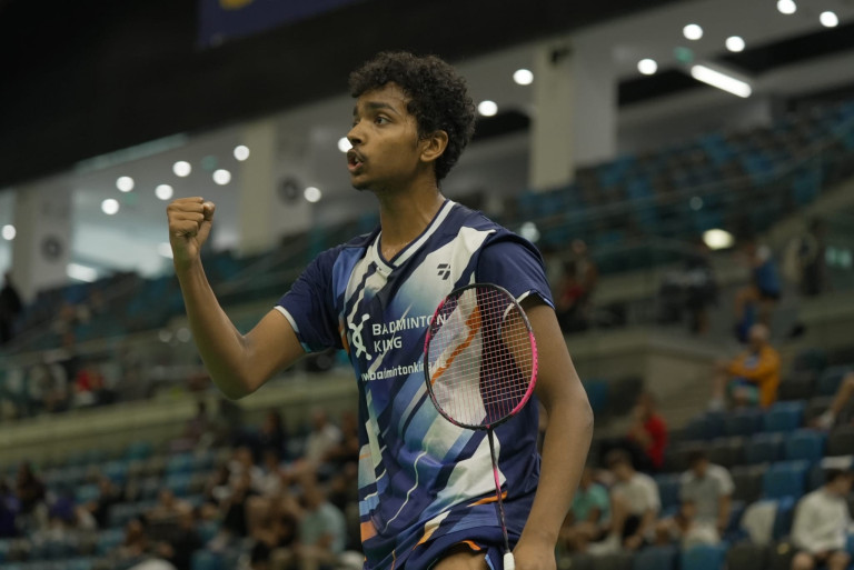 Badmintonspieler jubelt nach einem Punktgewinn in einer Sporthalle