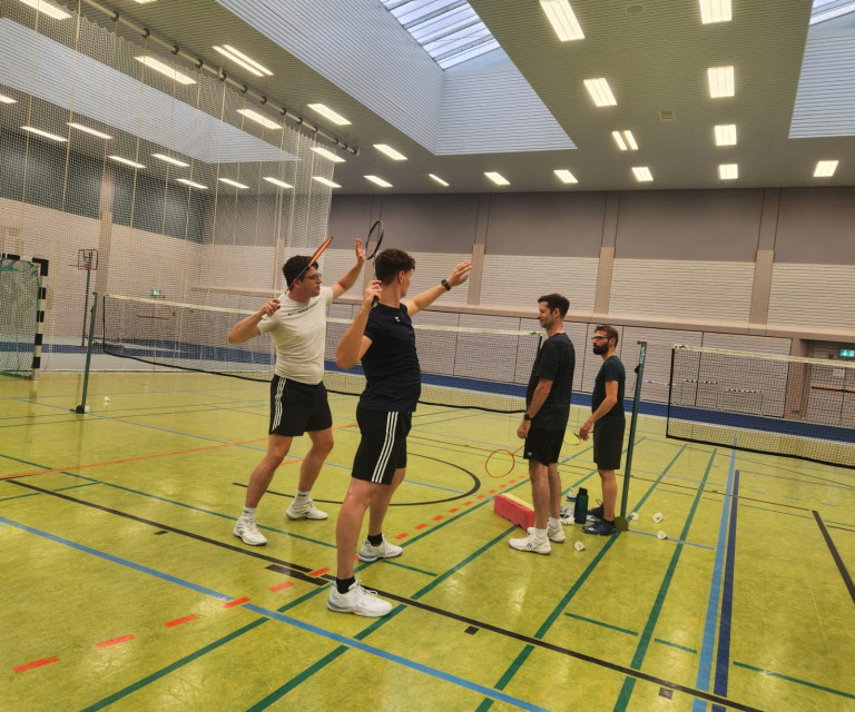 Teilnehmer beim Hobby Breitensportcamp spielen Badminton in einer Sporthalle