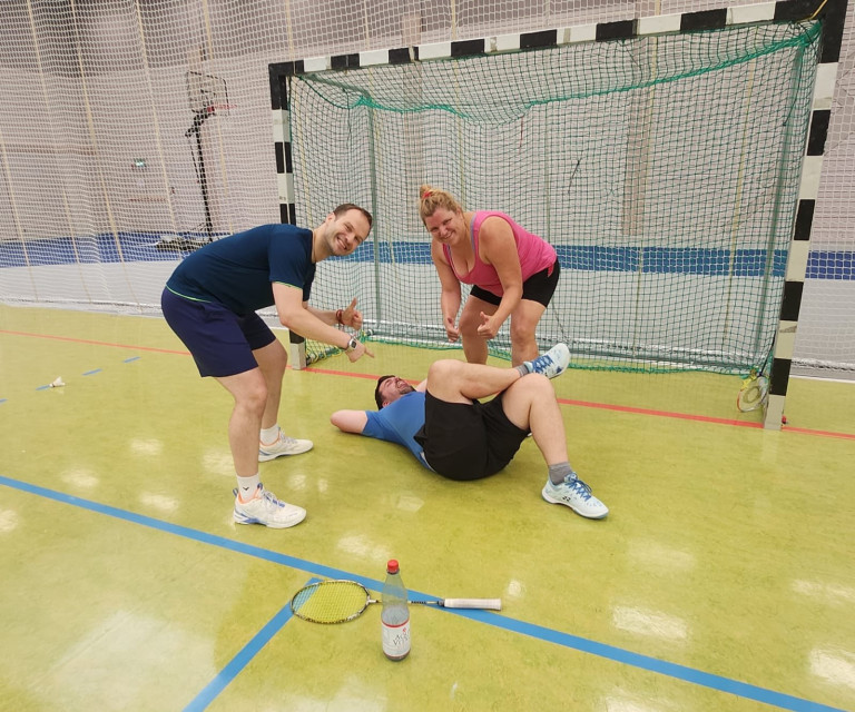 Teilnehmer beim Hobby-Breitensportcamp in der Sporthalle mit Badminton-Schläger und Spaß am Netz