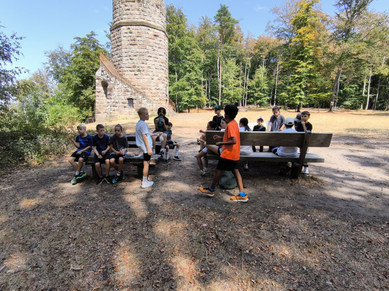 LLZ Sommercamp 2023 – Kindergruppe am historischen Turm im Wald Kinder beim LLZ Sommercamp 2023 vor einem historischen Turm im Wald