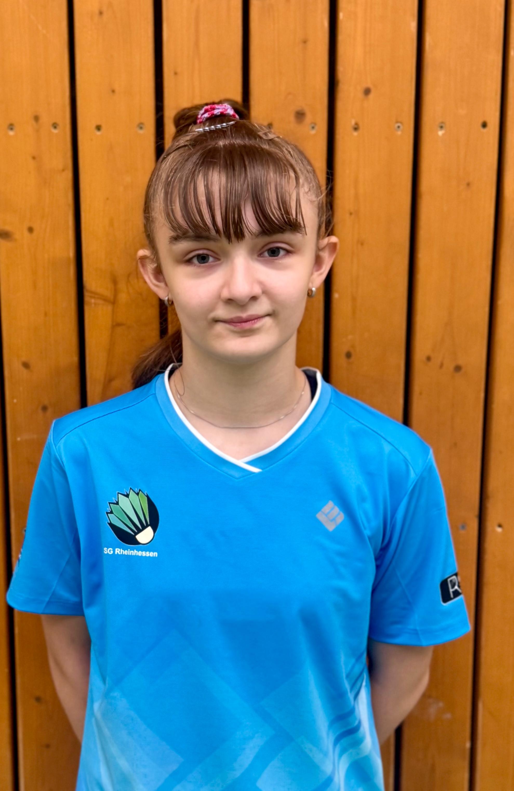 Sportlerin im blauen Trikot der SG Rheinhessen vor einer Holz-Wand