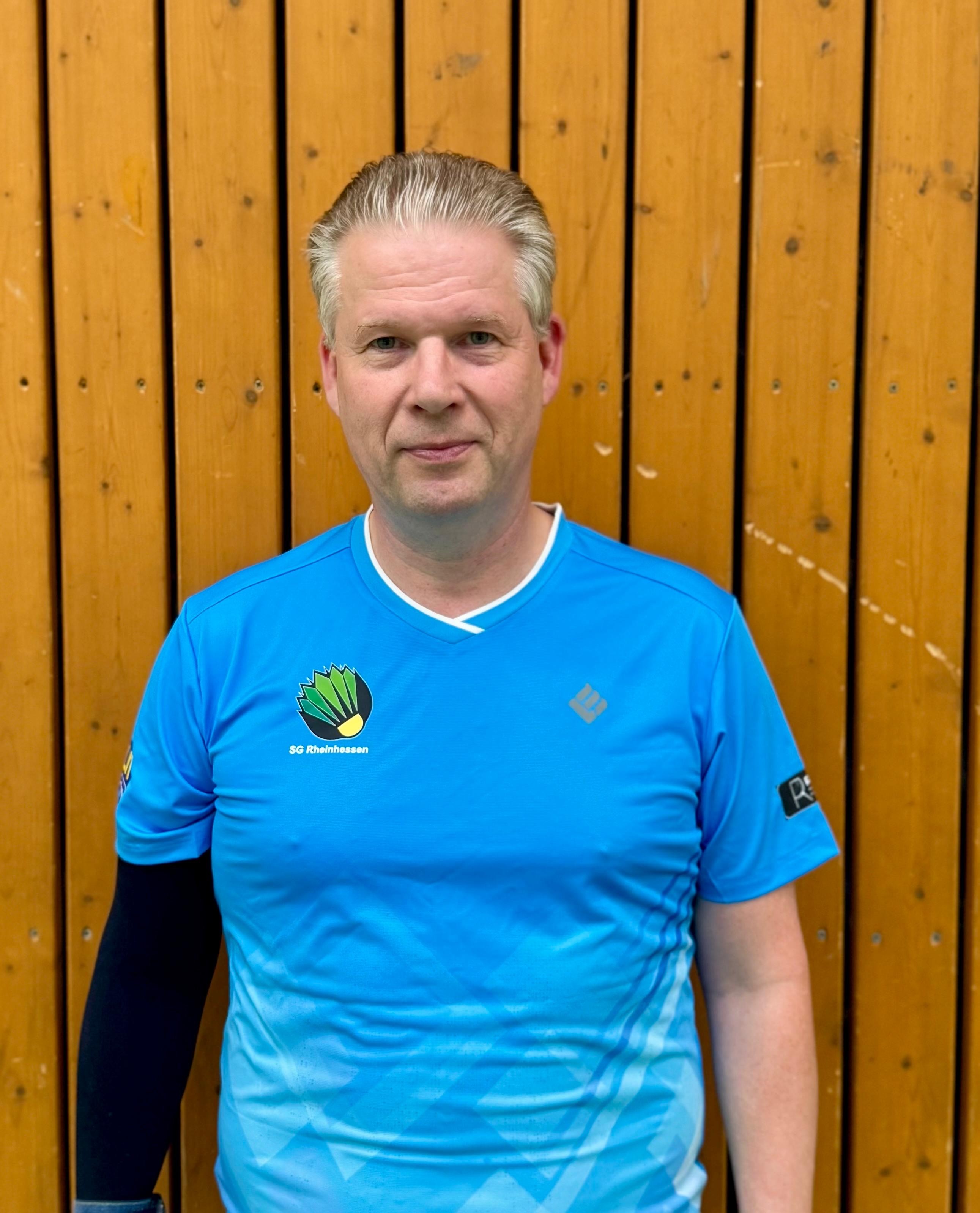 Sportler im blauen Trikot der SG Rheinhessen vor Holzwand