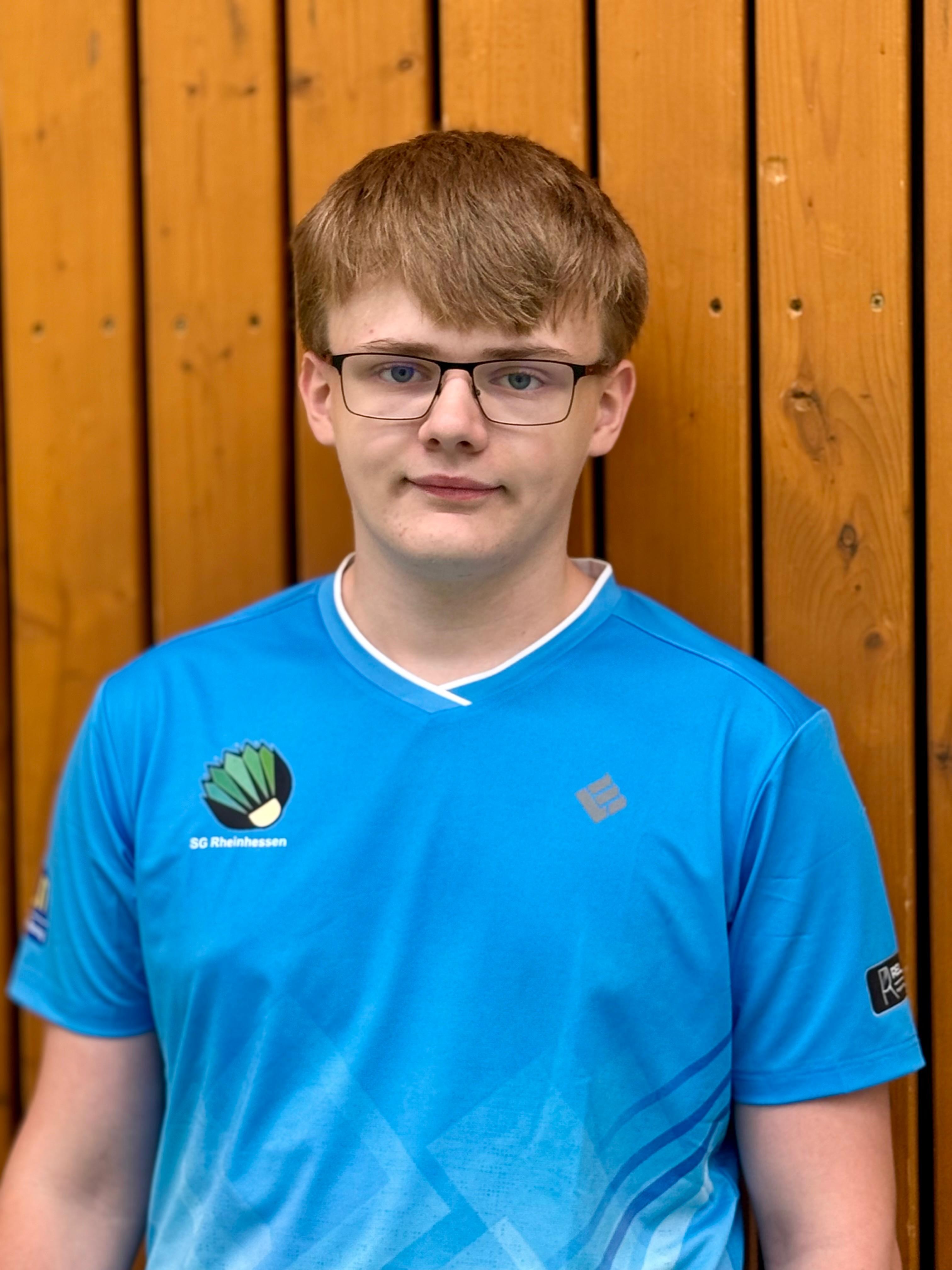 Mitglied der SG Rheinhessen im blauen Trikot vor Holzwand