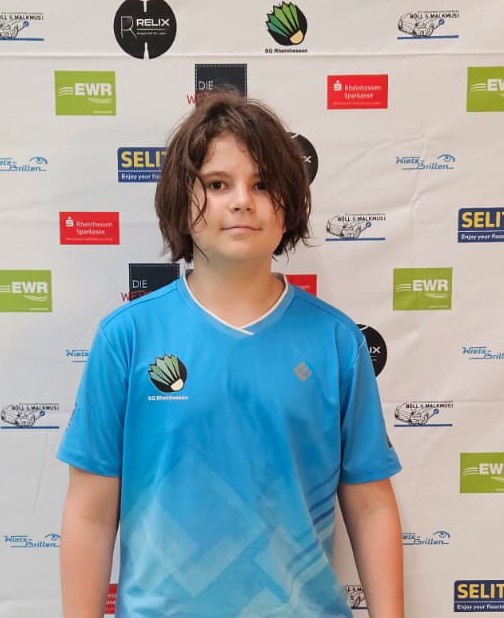 Adrian Trendler im blauen Trikot des SC Bingenheim vor Sponsorenwand