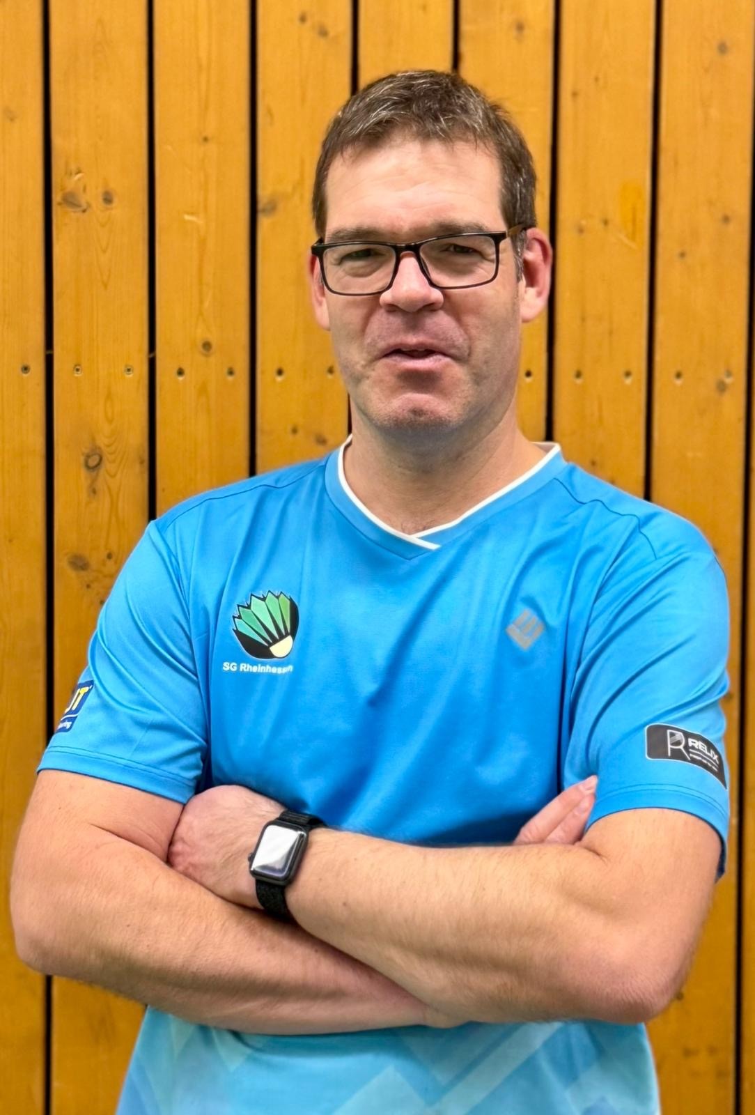 Andreas Brauns im SG Rheinhessen Trikot vor Holzwand