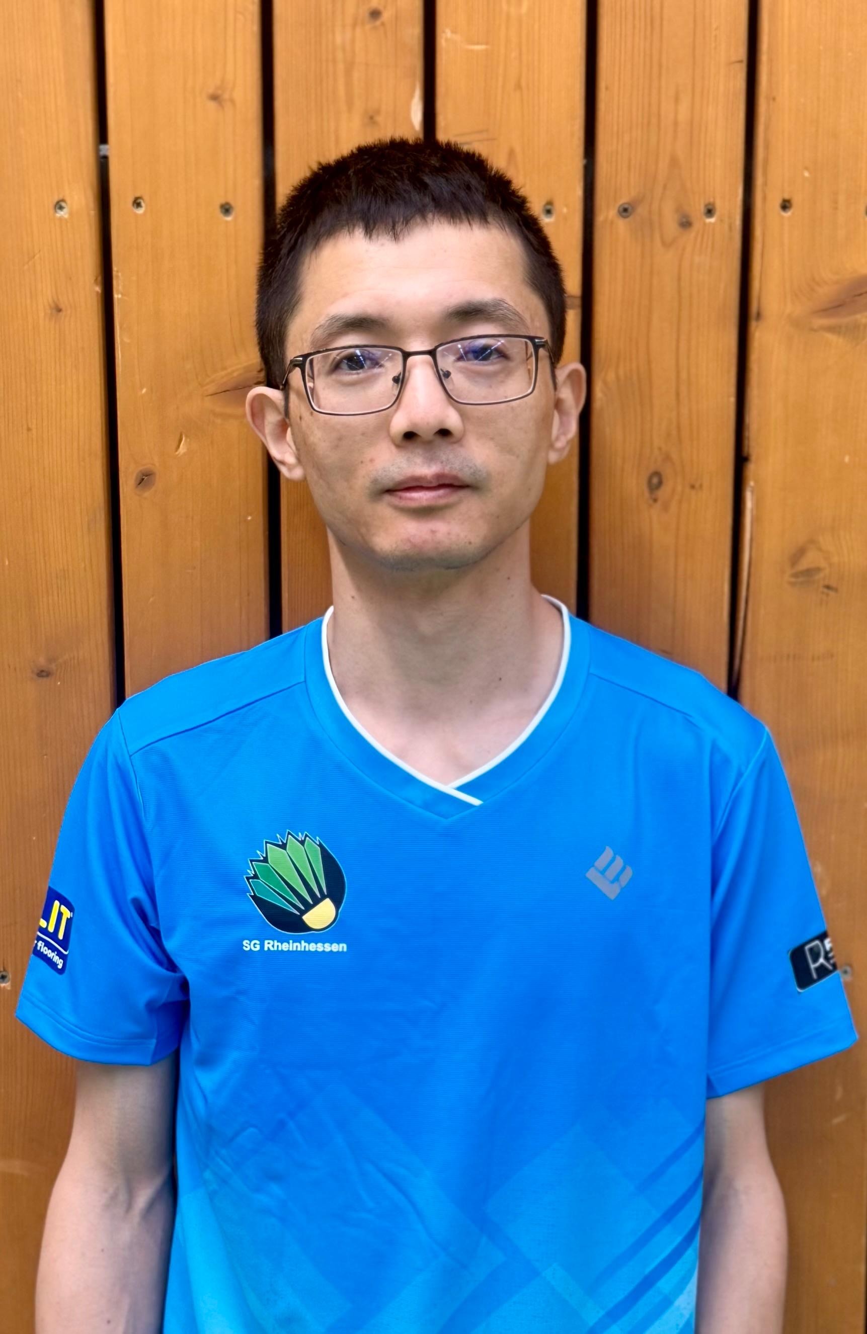 Sicheng Zhong im SG Rheinhessen Trikot vor Holzwand