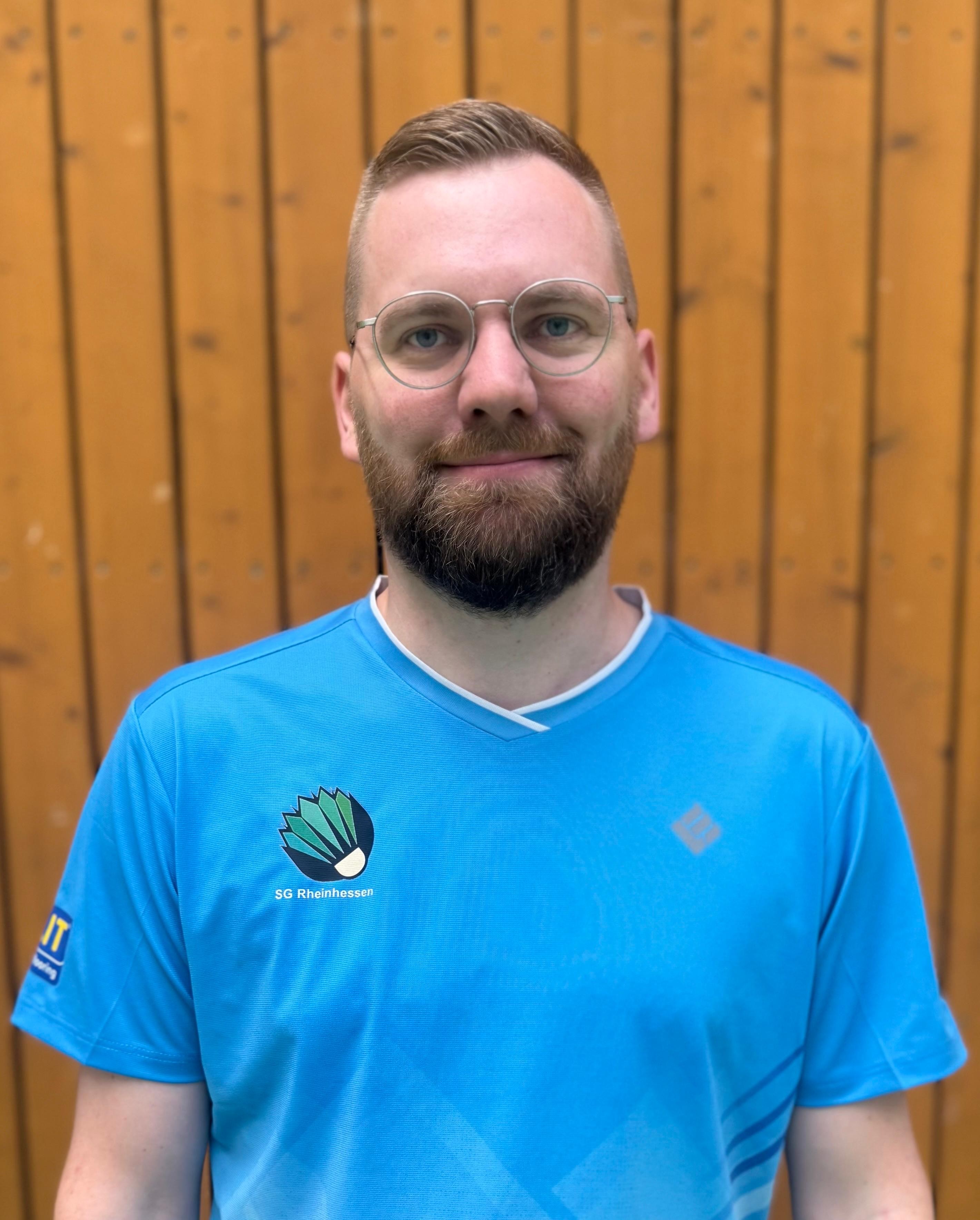 Matthias Hoffmann im SG Rheinhessen Trikot vor Holz-Wand