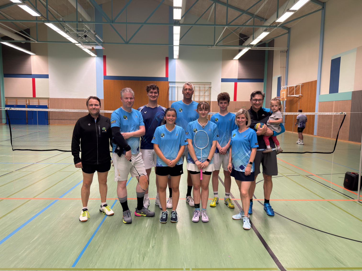 Gruppenfoto eines Badminton-Teams in einer Sporthalle