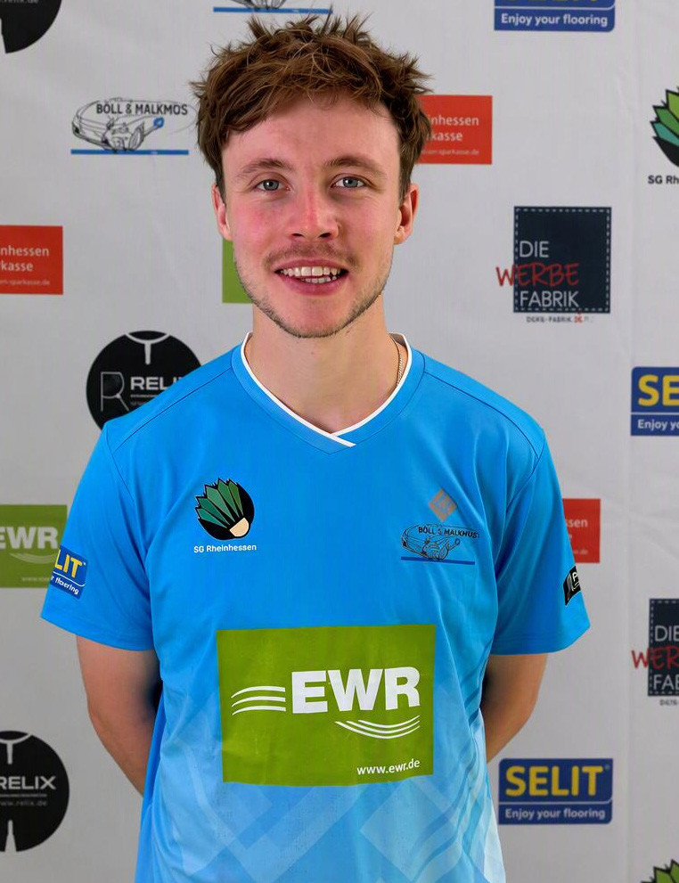 Levin im blauen SG Rheinhessen Trikot vor Sponsorenwand