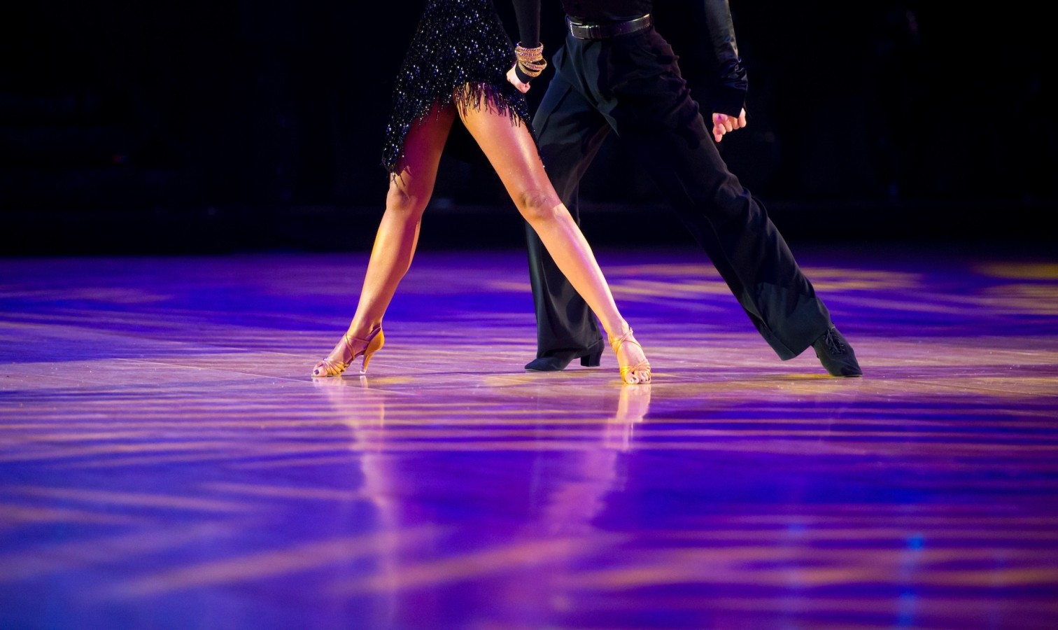 Tanzpaar beim lateinamerikanischen Turniertanz auf Parkettboden