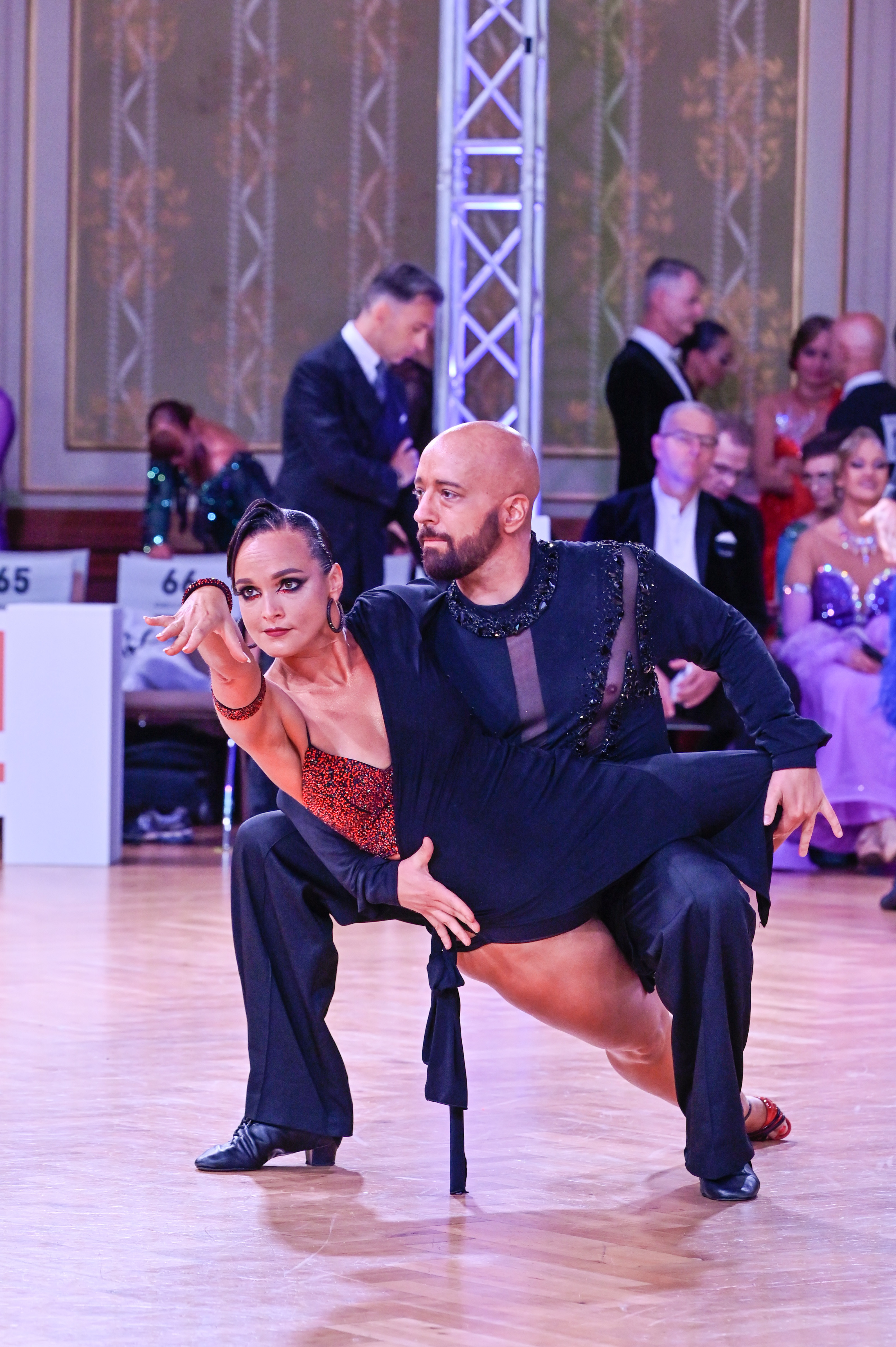 Tanzpaar bei einem Turnier in einer dynamischen Tanzpose auf dem Parkett