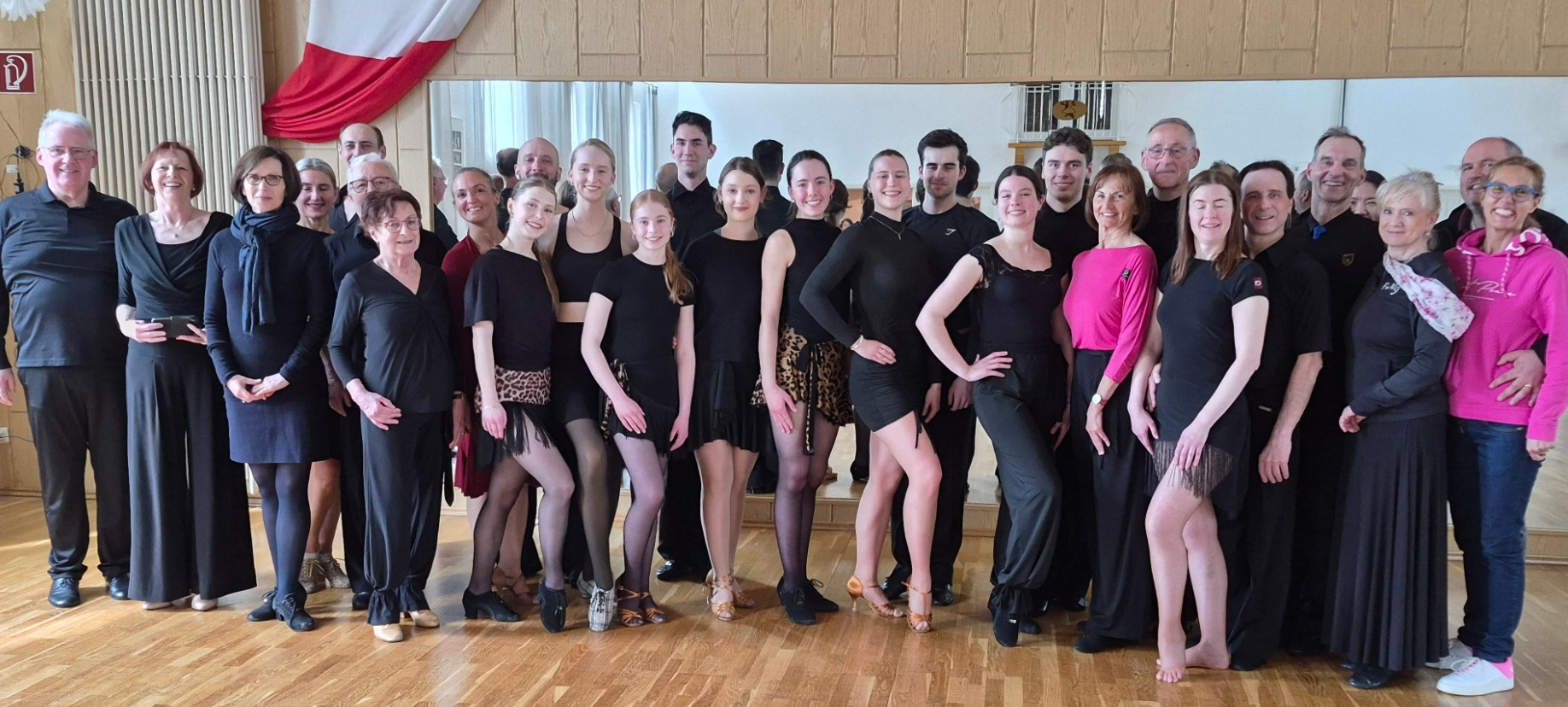 Tanzgruppe beim Wettbewerbstraining in einem Tanzstudio, mehrere Tänzerinnen und Tänzer in Trainingskleidung