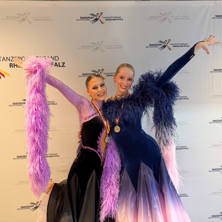 Landesmeisterschaft Tanzsport Rheinland-Pfalz – Siegerinnen mit Medaillen Siegerinnen bei der Landesmeisterschaft im Tanzsport Rheinland-Pfalz, festlich gekleidet mit Medaillen vor dem Banner des Tanzsportverbands