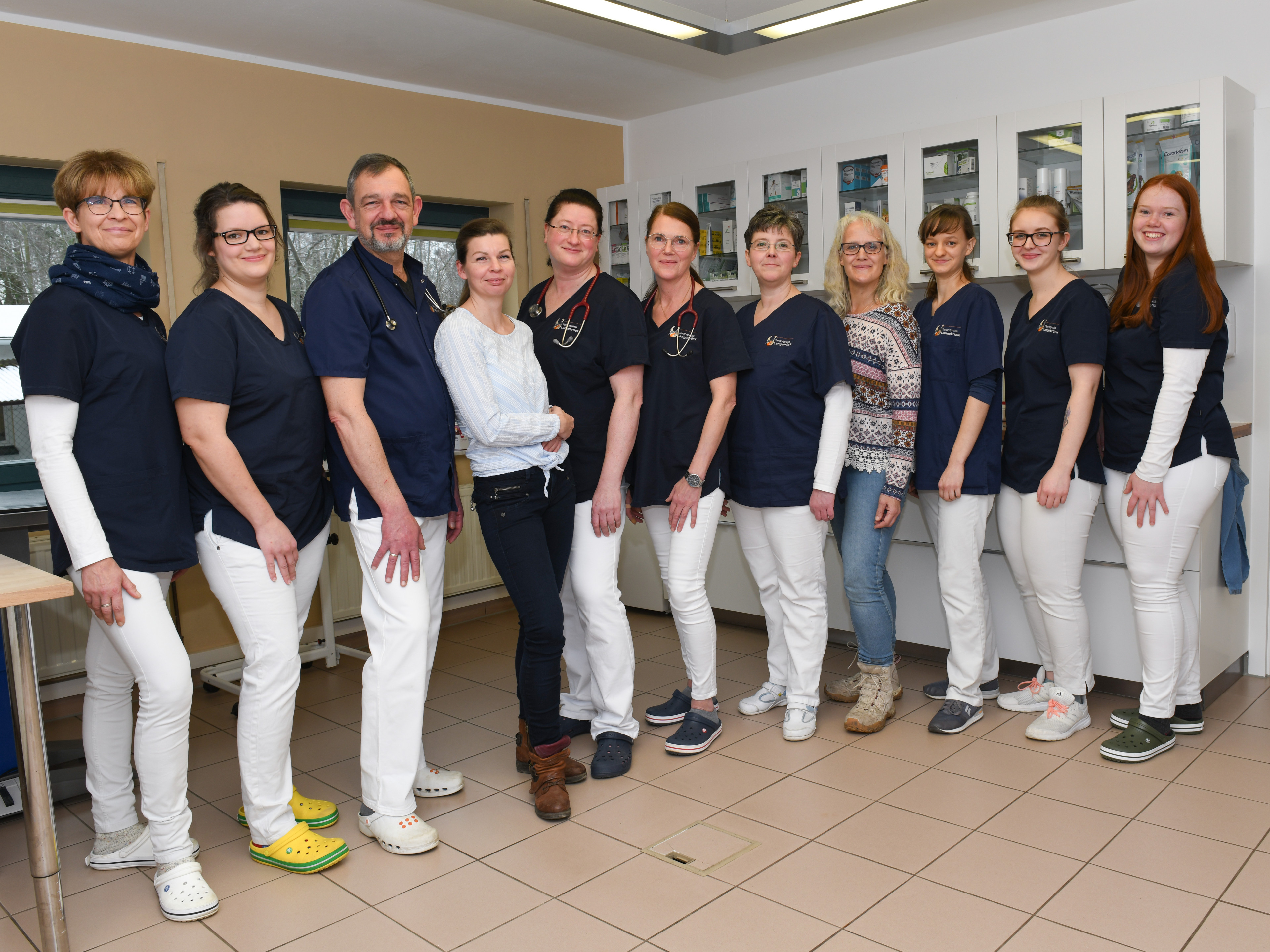 Teamfoto medizinisches Personal in Praxis mit blauen Kitteln