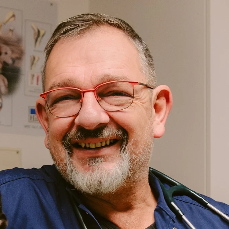 Mathias Ehrlich mit Stethoskop in einer Arztpraxis