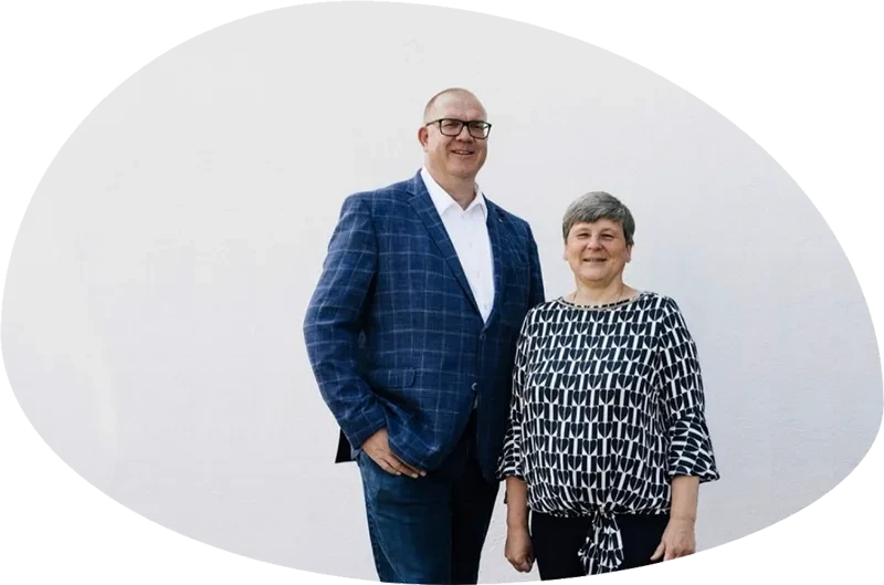 Joerg Hinrichs und Nicole Deutschewitz stehen gemeinsam vor einer weißen Wand