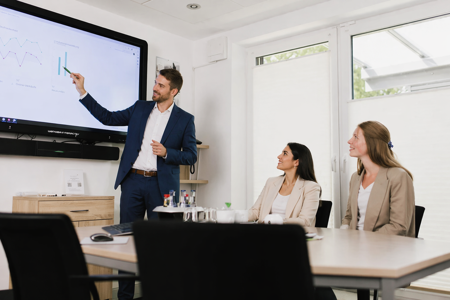 Steuerberater Hinrichs bei einer Präsentation in Magdeburg und Oldenburg, Teammeeting im modernen Büro