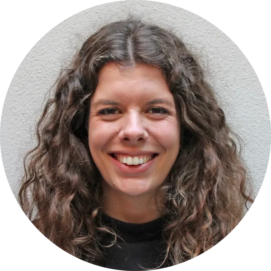 Porträtfoto von Cornelia mit lockigen Haaren vor einer hellen Wand