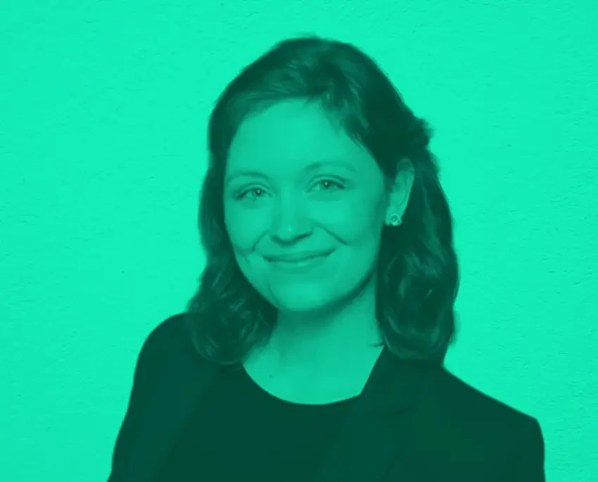 Porträtfoto von Debora mit dunklem Haar und schwarzem Oberteil vor türkisfarbenem Hintergrund