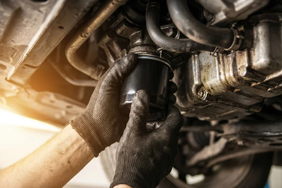 teaser old young – Mechanikerhände beim Wechsel eines Ölfilters an einem Auto