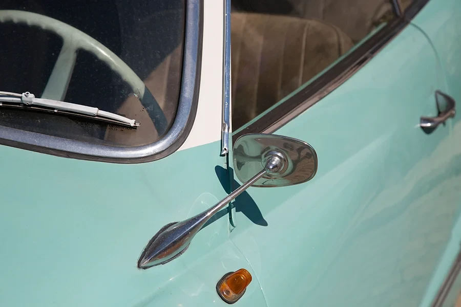 Detailaufnahme einer klassischen Karosse mit Außenspiegel und türkisfarbener Lackierung