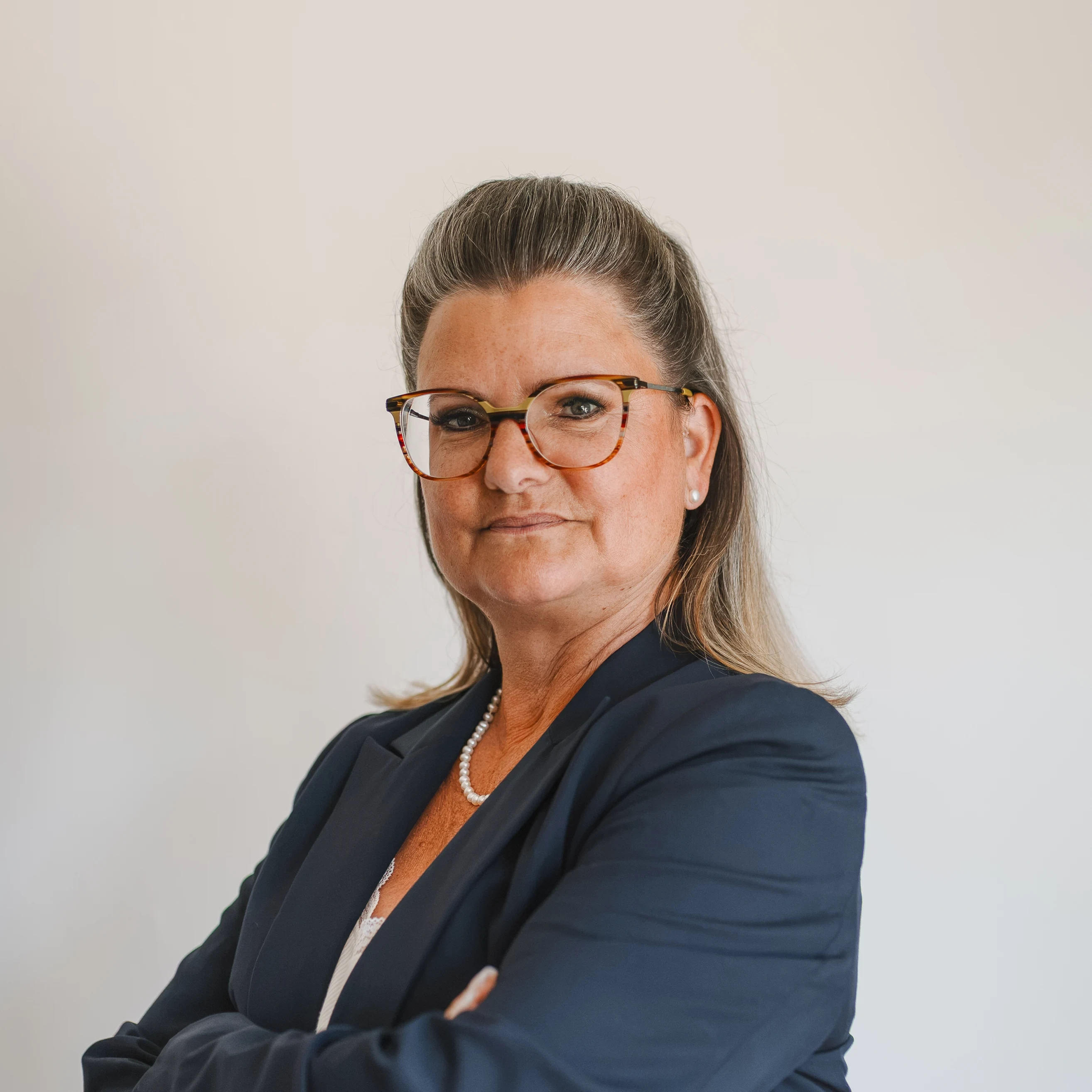 Porträt von Karmen Kreihe im Business-Outfit vor hellem Hintergrund
