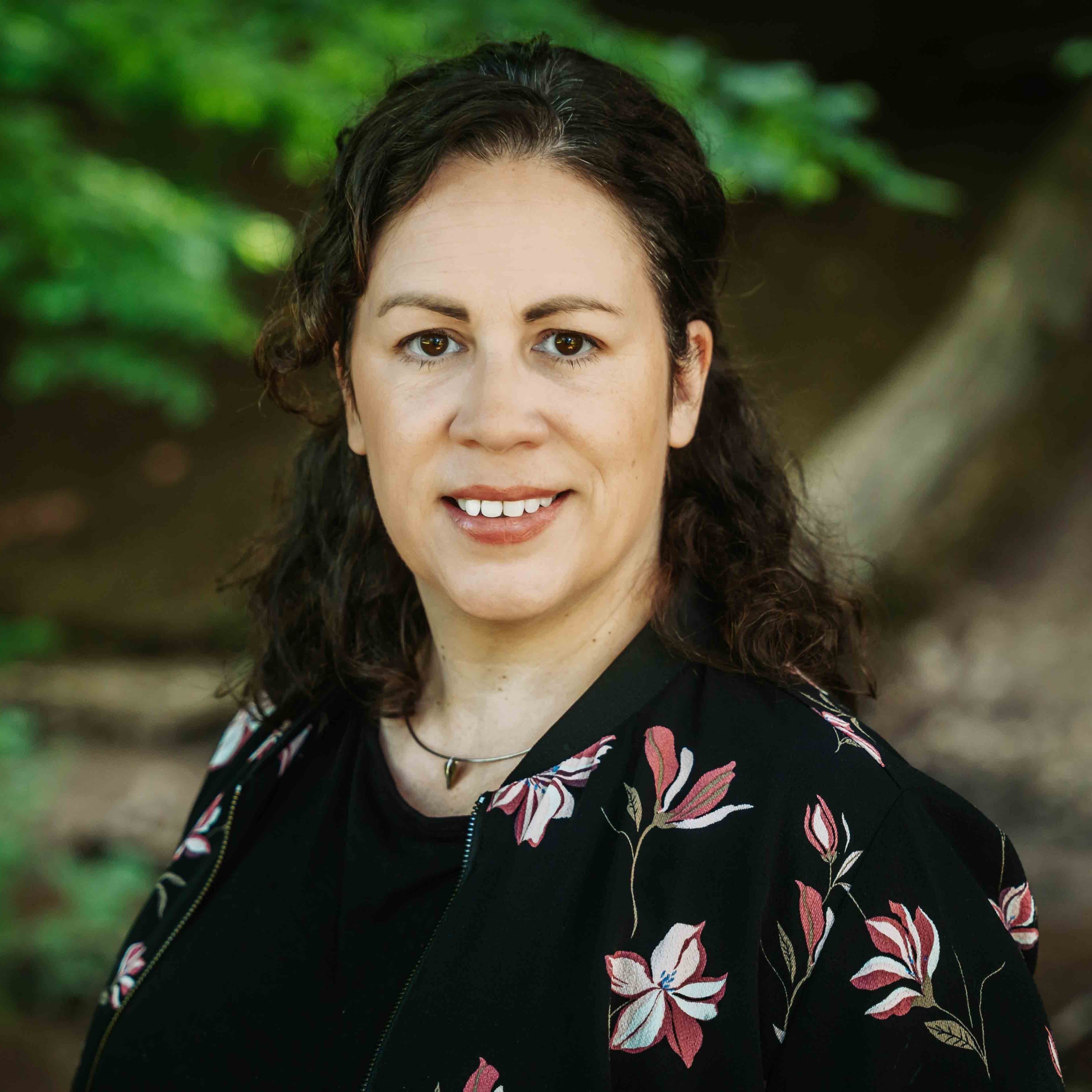 Alea Portrait im Grünen mit floralem Muster auf der Jacke