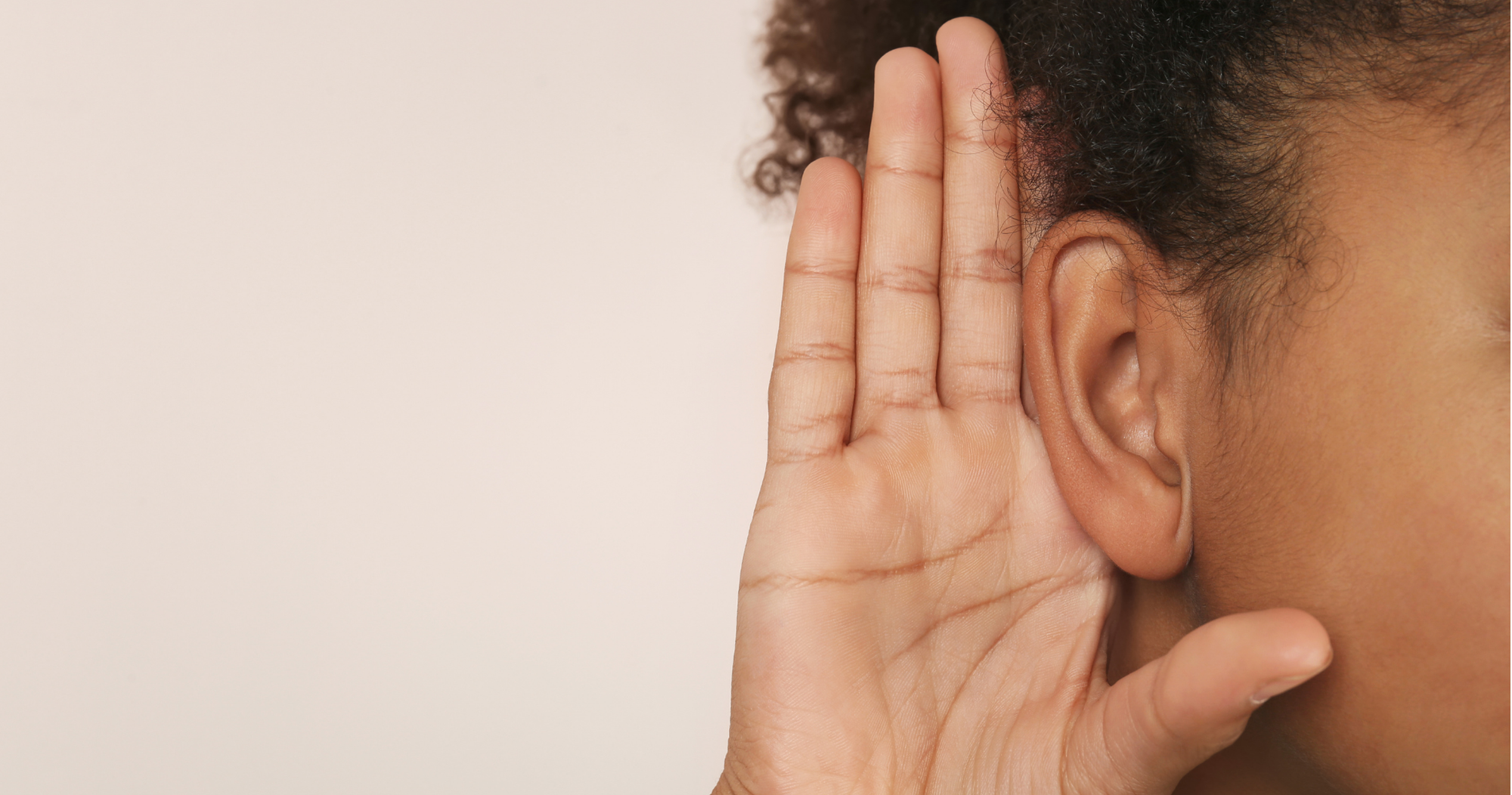 Person hält Hand ans Ohr zum besseren Zuhören