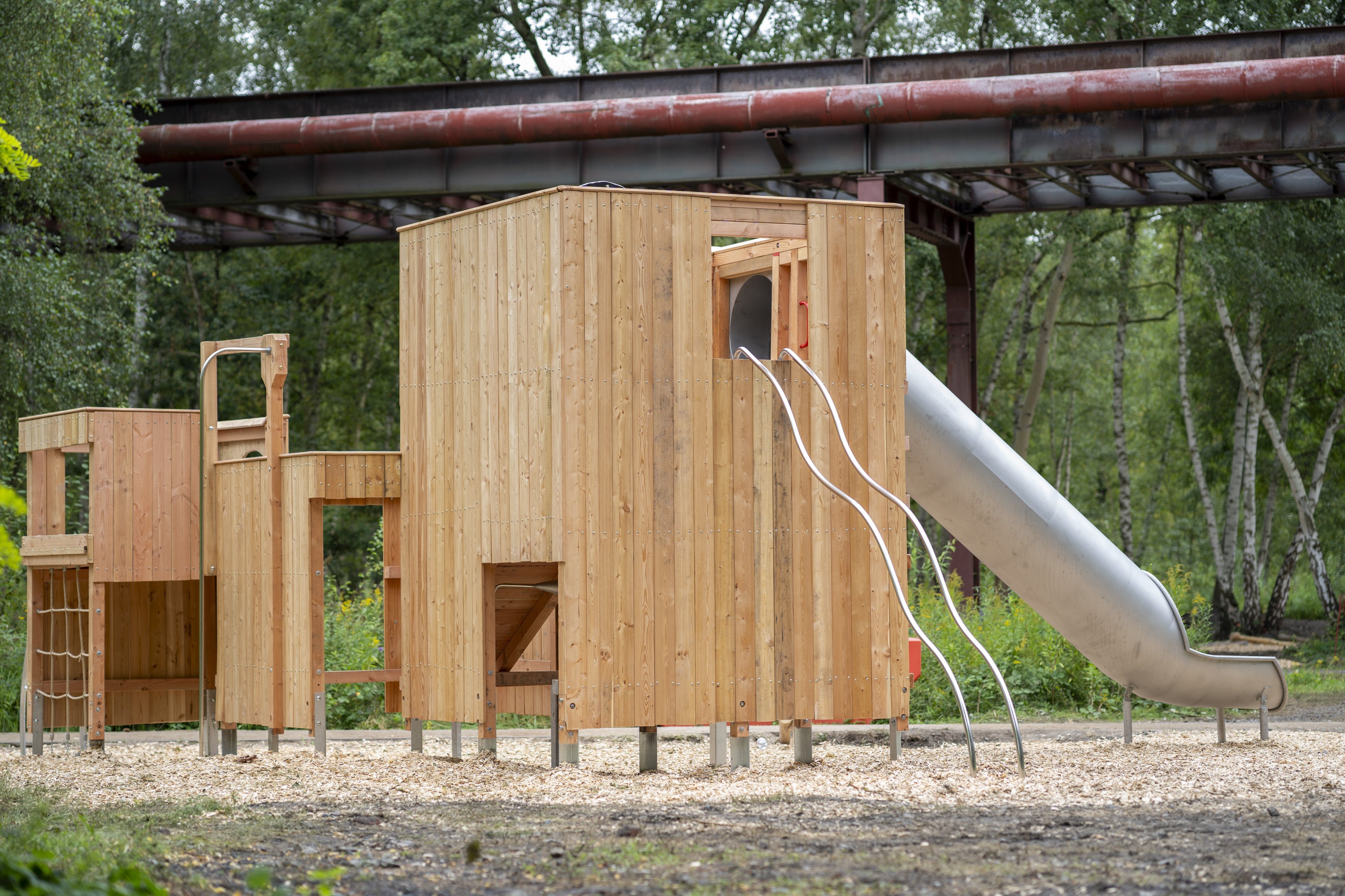 Moderner Holzspielplatz mit Rutsche und Kletterelementen im Freien
