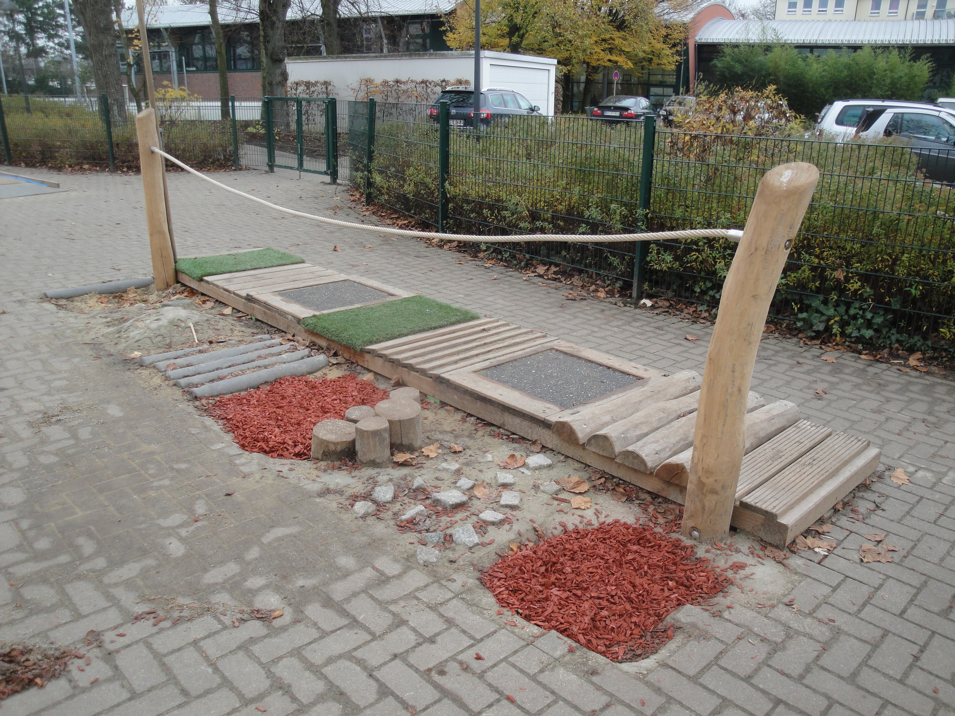 Barfußpfad aus Holz und verschiedenen Materialien auf einem Gehweg im Freien
