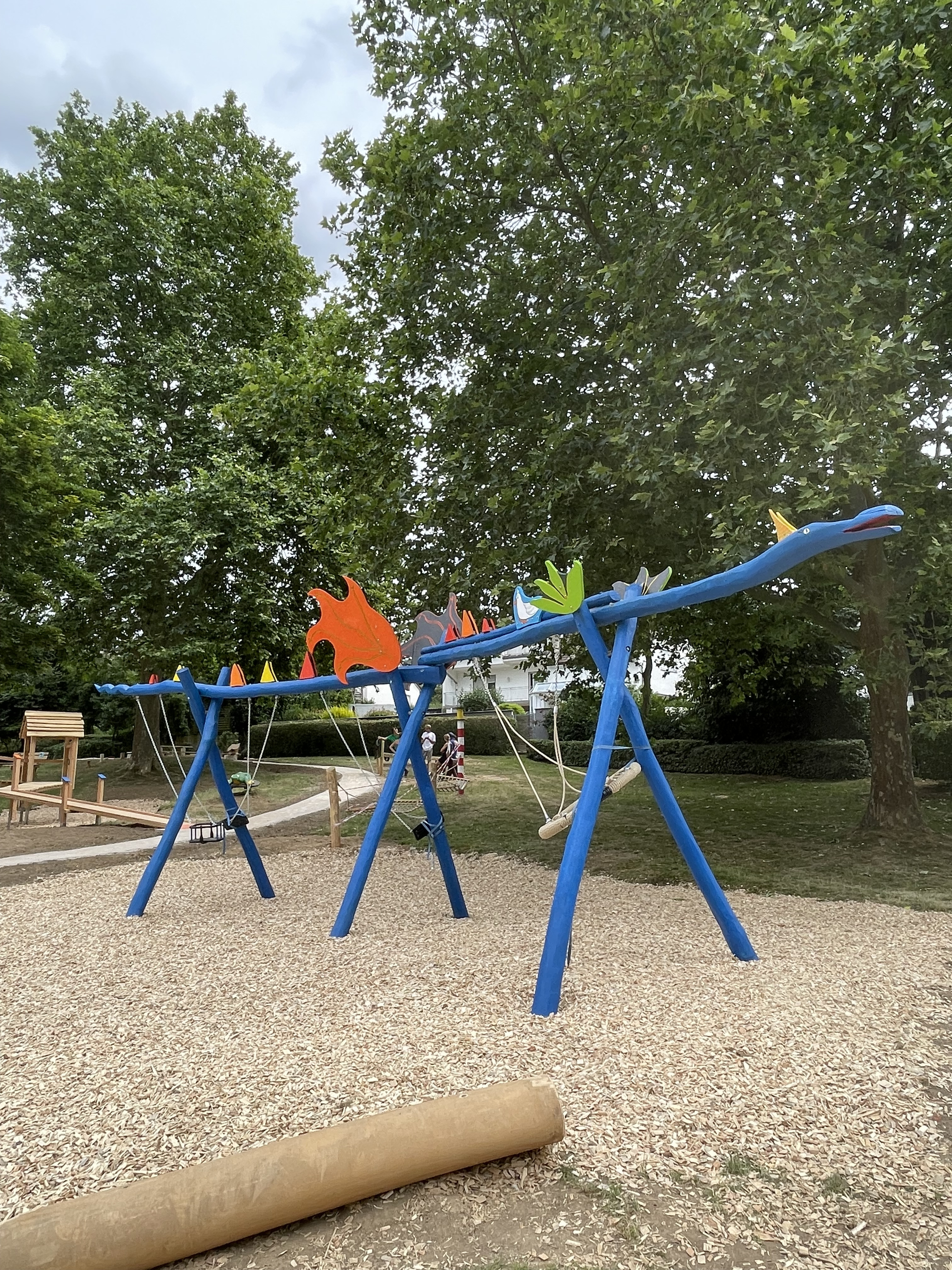 Bunte Drachenschaukel auf einem modernen Spielplatz im Grünen