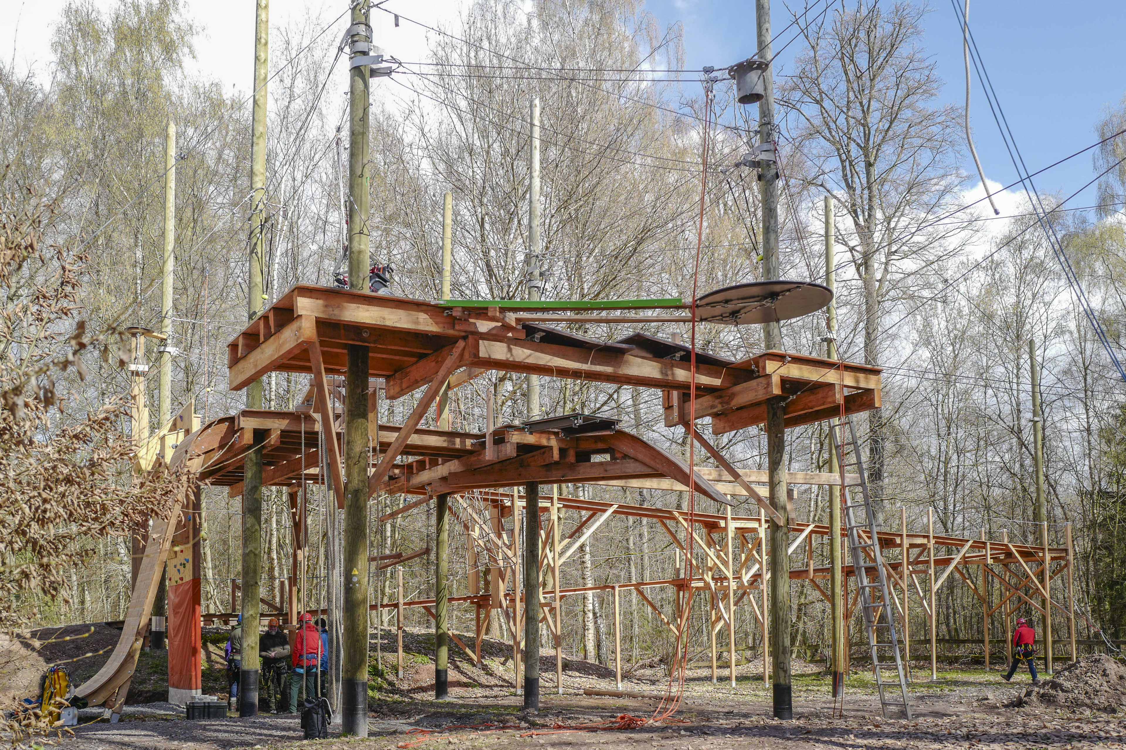Kletterpark mit Hochseilgarten im Wald, Holzkonstruktion und Seilparcours