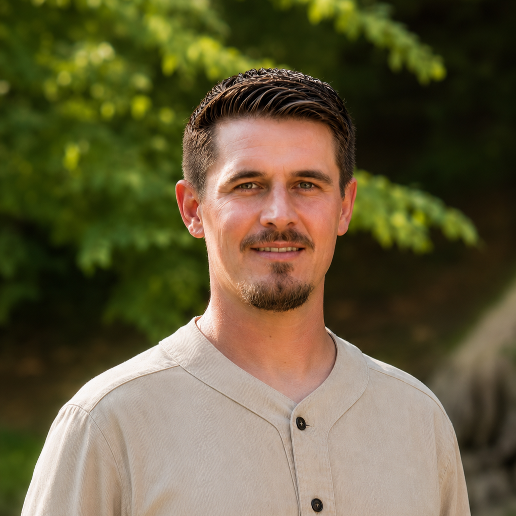 Portrait von Marius Riedel im Freien vor grünem Hintergrund