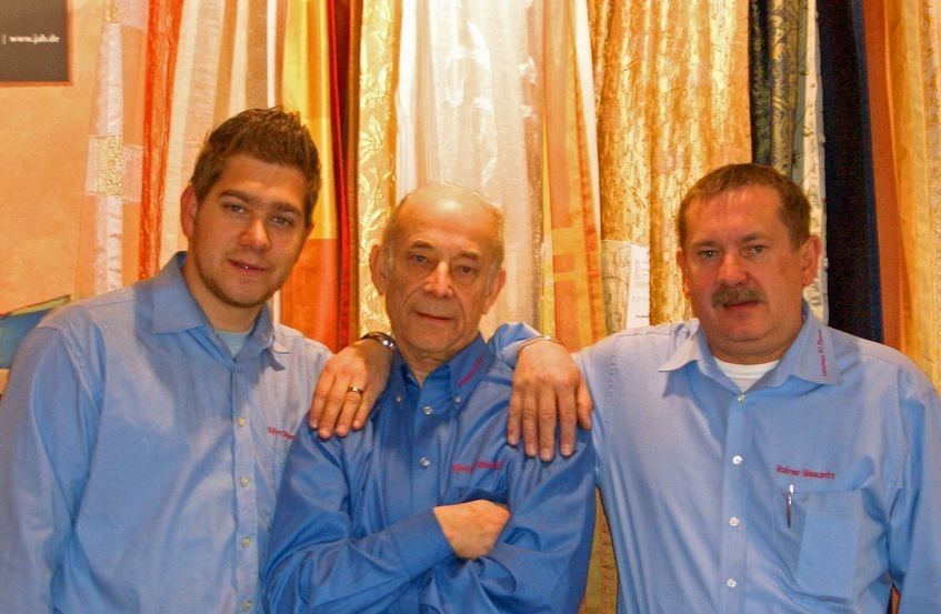 Bissantz Generationen, Gruppenfoto mit Christoph Blüthner, drei Personen in blauen Hemden vor farbigen Vorhängen