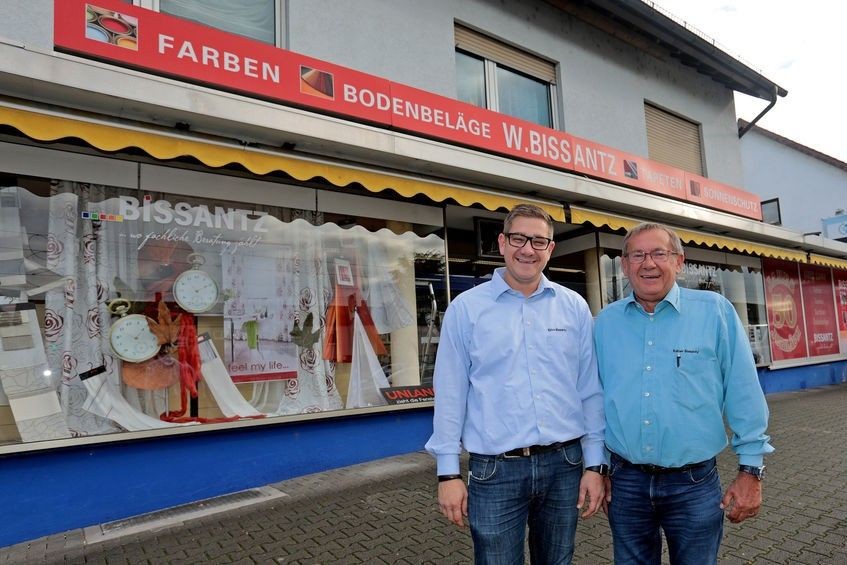 Geschäft W. Bissantz für Farben und Bodenbeläge, Außenansicht mit zwei Personen vor dem Laden, Foto von Christoph Bluthner