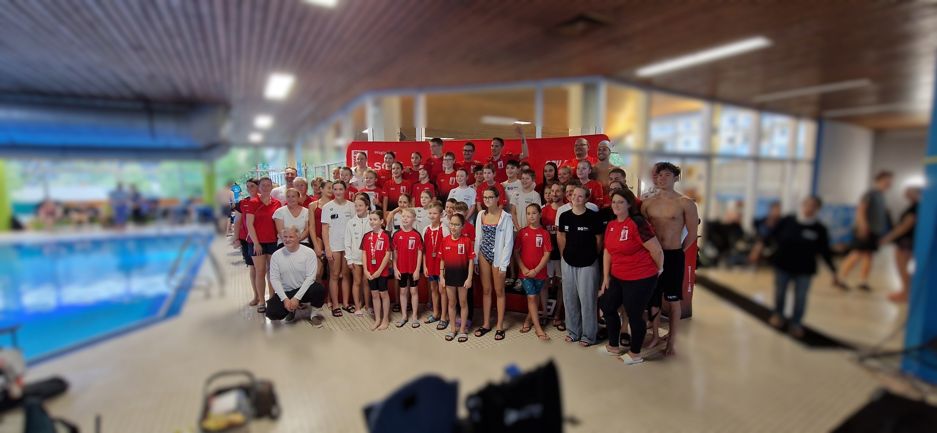 Gruppenfoto einer Schwimmmannschaft mit Kindern und Erwachsenen im Schwimmbad, aufgenommen am 21.09.2025
