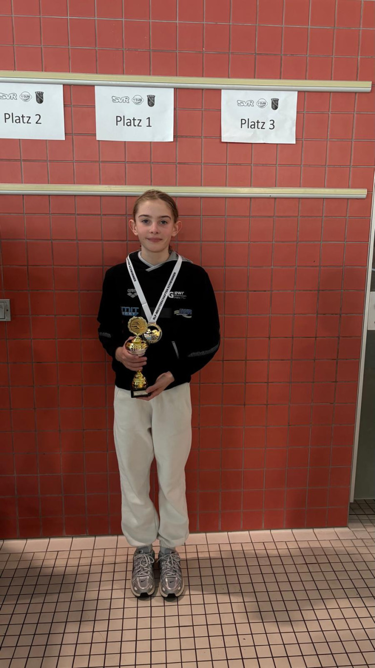 Jugendlicher mit Medaillen und Pokal nach erfolgreichem Wettkampf am 23.03.2026 Jugendlicher Sportler mit Medaillen und Pokal vor roter Fliesenwand nach Wettkampf