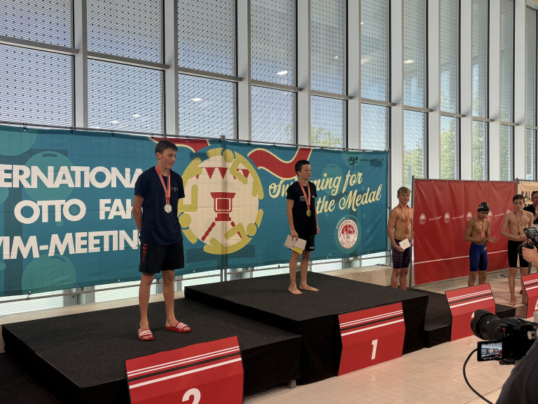 Siegerehrung bei einem Schwimmwettkampf mit drei jungen Schwimmern auf dem Podest