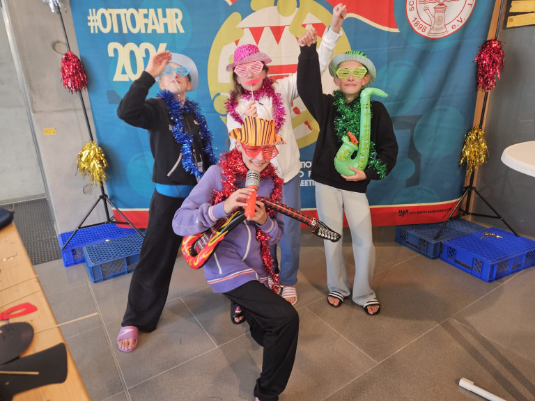 Kinder verkleidet mit Instrumenten und bunten Accessoires vor Ottofahr 2024 Fotowand