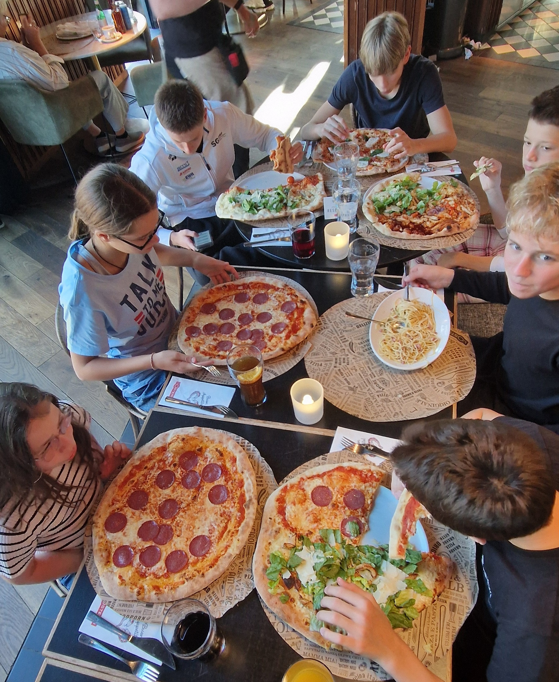 Gruppe von Jugendlichen isst Pizza und Pasta in einem Restaurant, aufgenommen am 22.05.2026