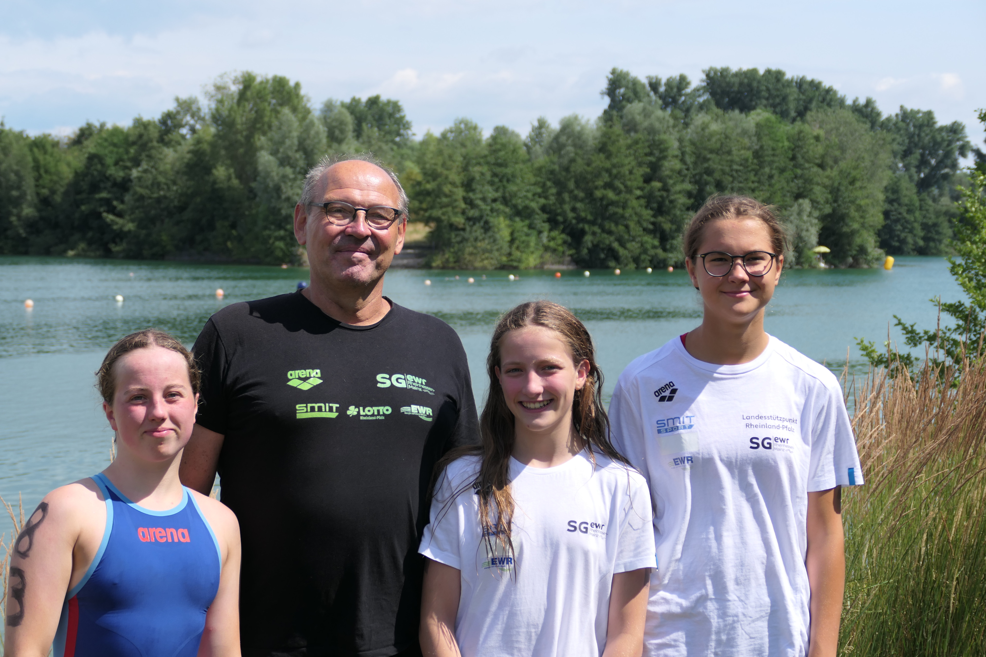 Trainer und junge Schwimmerinnen der SG EWR Rheinhessen Mainz am See bei sonnigem Wetter