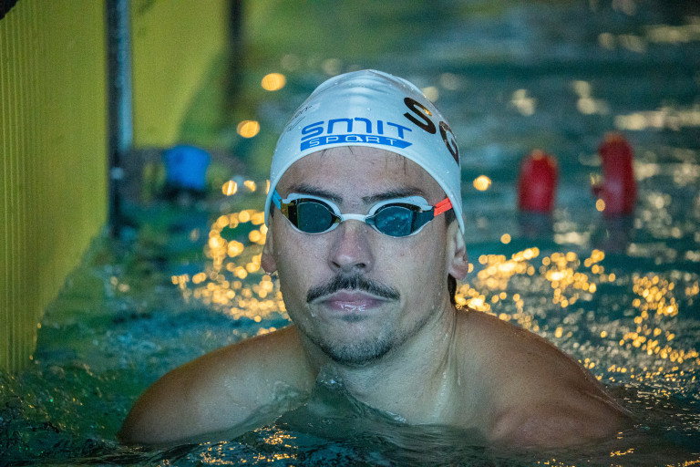 Schwimmer mit Schwimmbrille und SMIT SPORT Badekappe im Schwimmbad