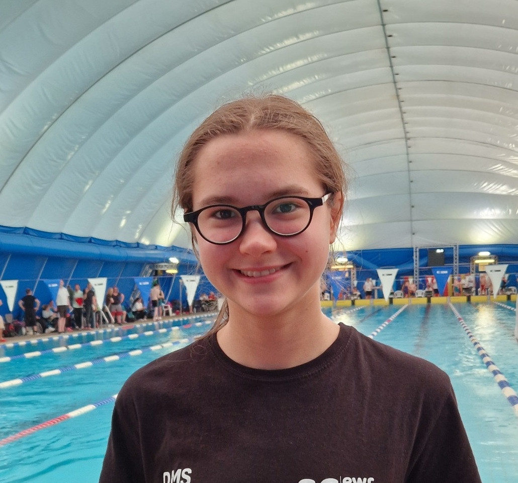 Mathilda am Schwimmbecken bei einem Schwimmwettkampf
