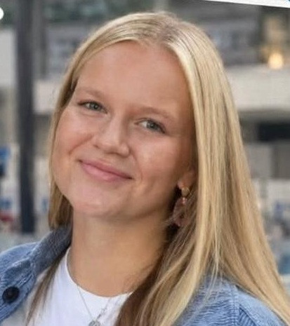 Porträtfoto von Lucy mit blondem Haar und freundlichem Lächeln