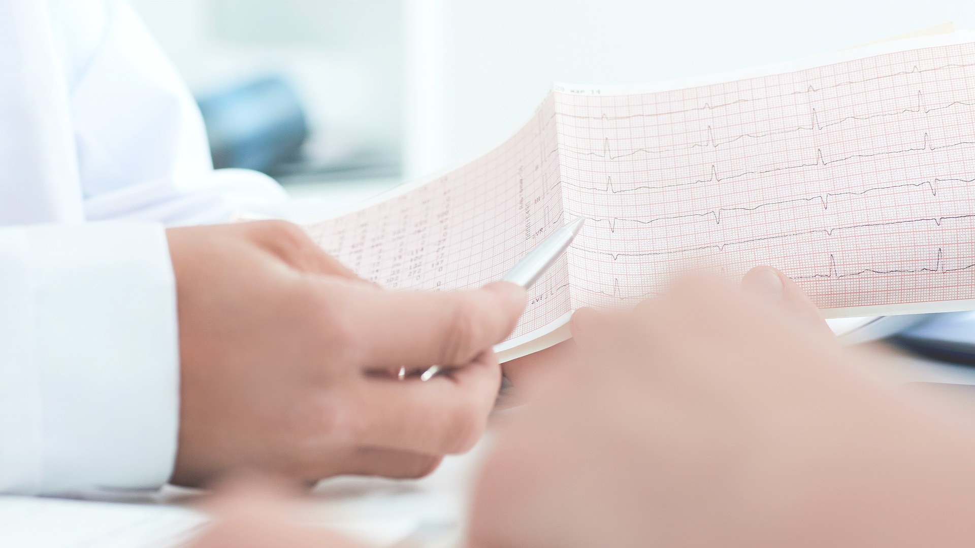 Arzt bespricht mit einer Patientin die Ergebnisse eines EKGs