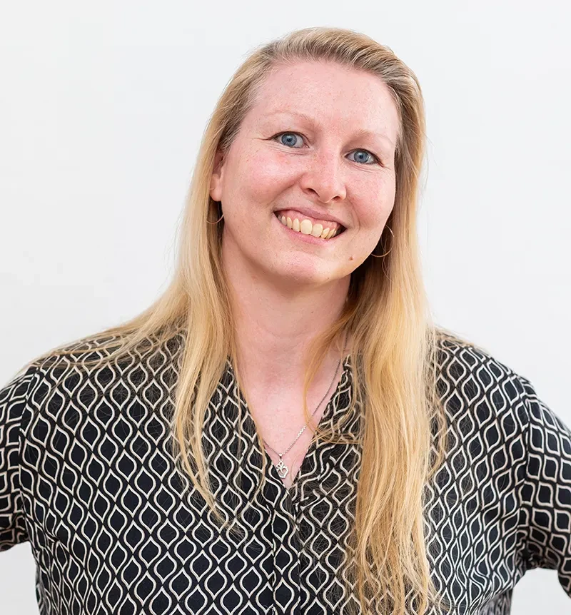 Cathleen Fischer – Porträtbild mit blondem Haar und gemustertem Oberteil Cathleen Fischer mit blondem Haar und gemustertem Oberteil